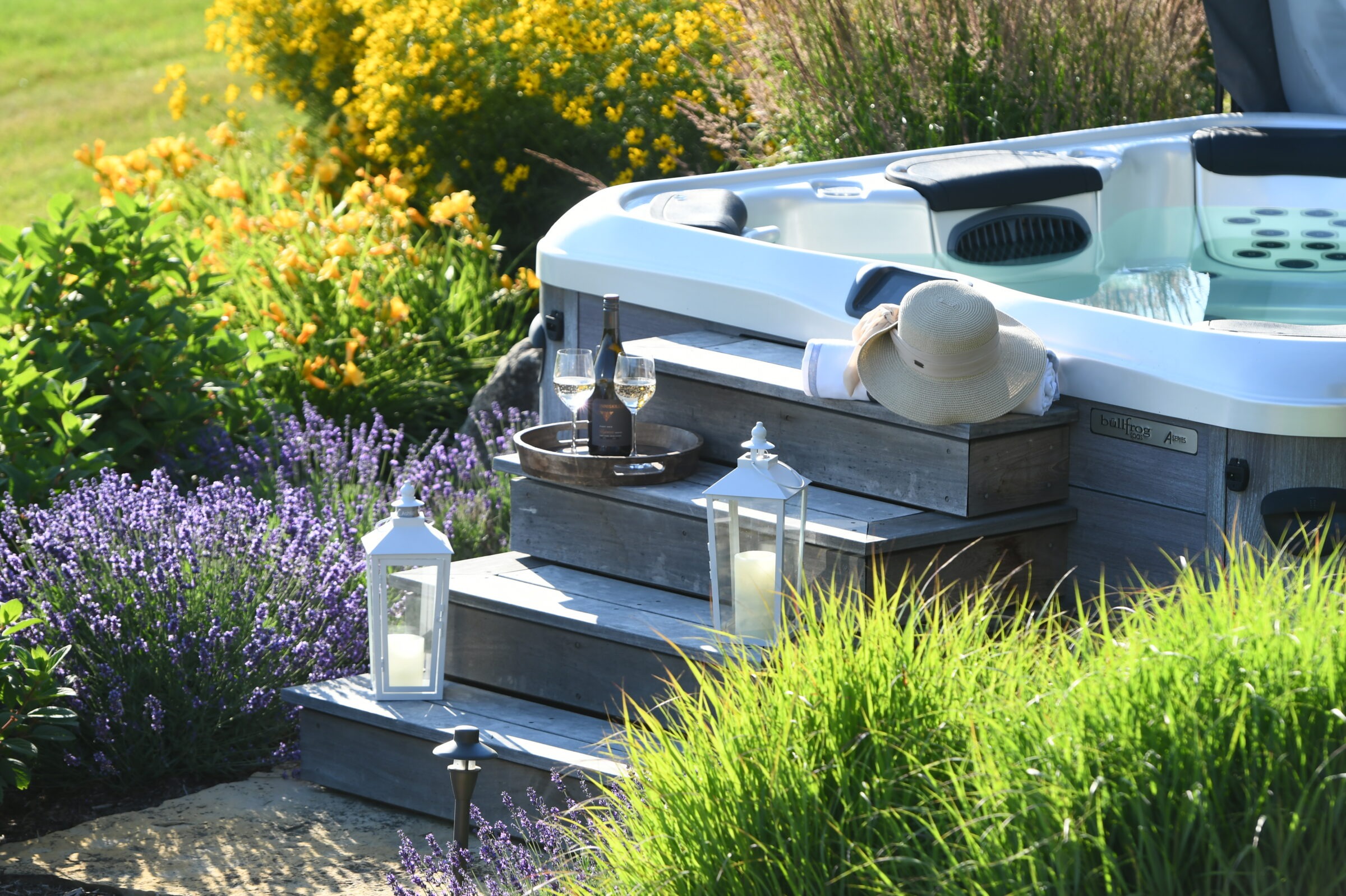 A serene garden scene with a hot tub, flowers, lanterns, wine bottle, and glasses, evoking relaxation and tranquility.