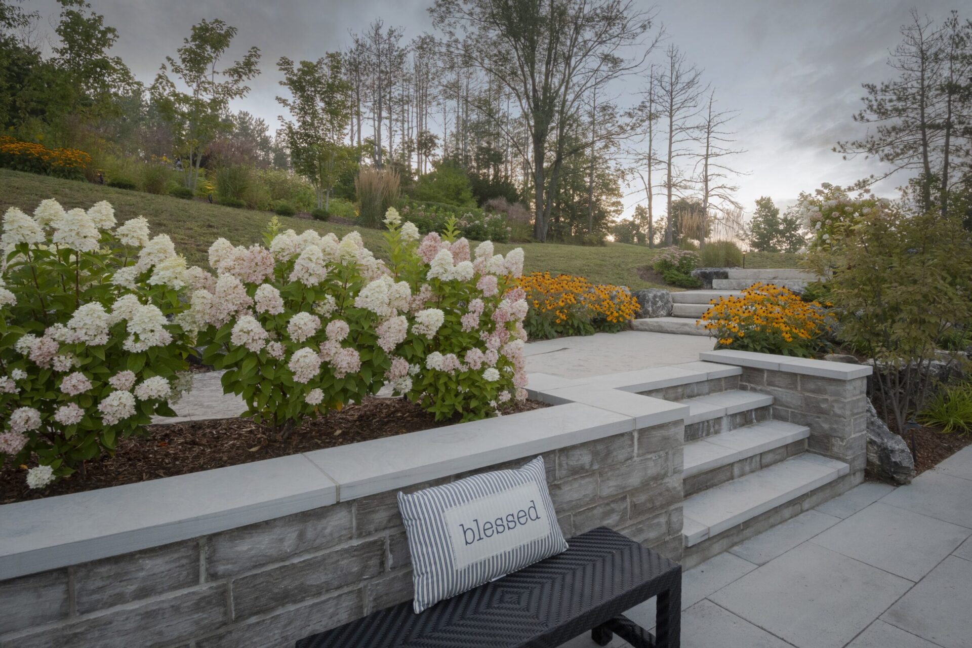 A serene garden scene with blooming hydrangeas, stone steps, and a bench featuring a 