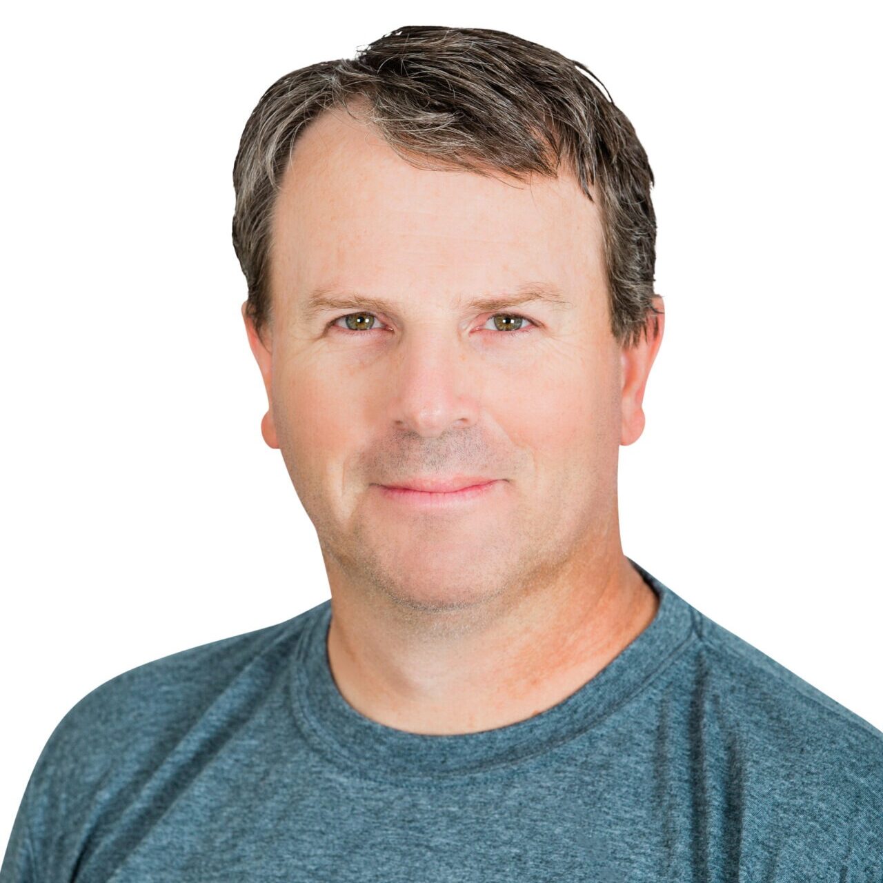 A person wearing a "Whispering Pines Landscaping" T-shirt stands against a plain white background, smiling slightly. No recognizable landmarks or historical buildings.