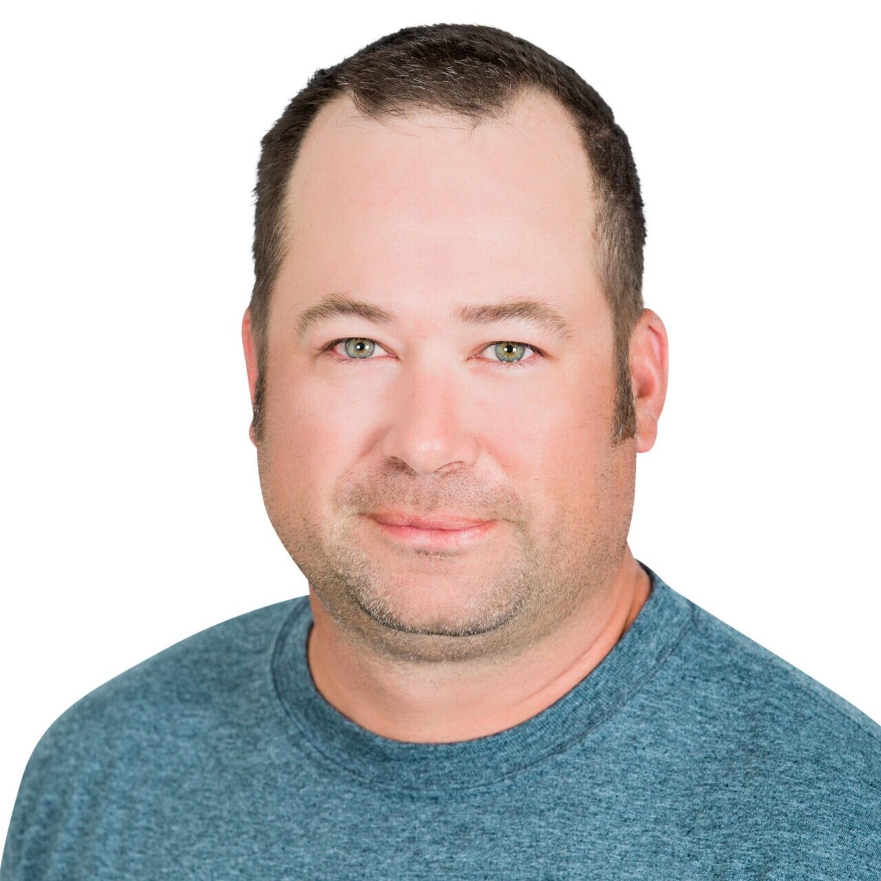 A person in a blue "Whispering Pines Landscaping" shirt faces forward, against a plain white background.